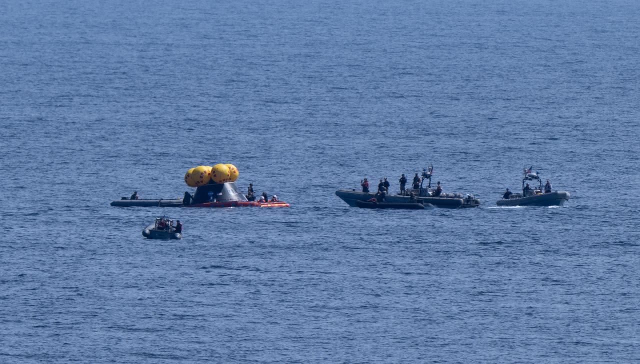 Teams work around the Crew Module Test Article (CMTA) as they practice recovery operations during Underway Recovery Test-12 onboard USS Somerset off the coast of California, Thursday, March 27, 2025. During the test, NASA and Department of Defense teams are practicing to ensure recovery procedures are validated as NASA plans to send the Artemis II astronauts around the Moon and splashdown in the Pacific Ocean. Photo Credit: (NASA/Joel Kowsky)