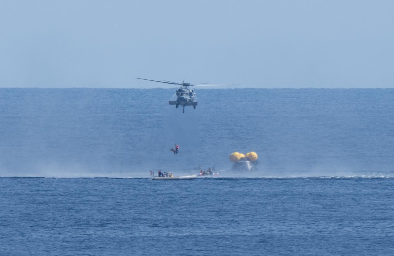 A Navy MH-60 Seahawk from Helicopter Sea Combat Squadron (HSC) 23 is seen as it lifts a training manikin as teams practice Artemis recovery procedures during Underway Recovery Test-12 onboard USS Somerset off the coast of California, Thursday, March 27, 2025. During the test, NASA and Department of Defense teams are practicing to ensure recovery procedures are validated as NASA plans to send the Artemis II astronauts around the Moon and splashdown in the Pacific Ocean.  Photo Credit: (NASA/Joel Kowsky)  1st lift