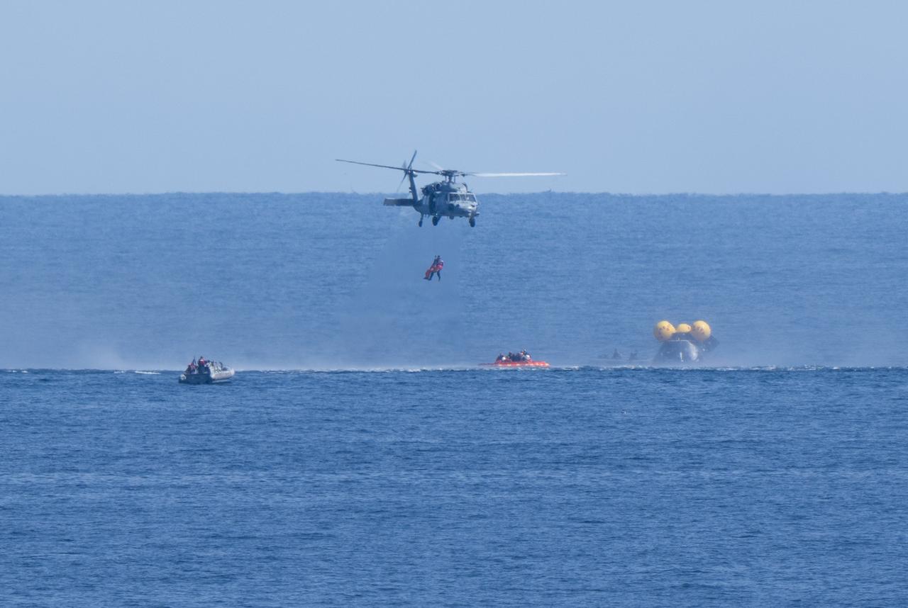 A Navy MH-60 Seahawk from Helicopter Sea Combat Squadron (HSC) 23 is seen as it lifts NASA astronaut Andre Douglas as teams practice Artemis recovery operations during Underway Recovery Test-12 onboard USS Somerset off the coast of California, Thursday, March 27, 2025. During the test, NASA and Department of Defense teams are practicing to ensure recovery procedures are validated as NASA plans to send the Artemis II astronauts around the Moon and splashdown in the Pacific Ocean.  Photo Credit: (NASA/Joel Kowsky)  2nd lift