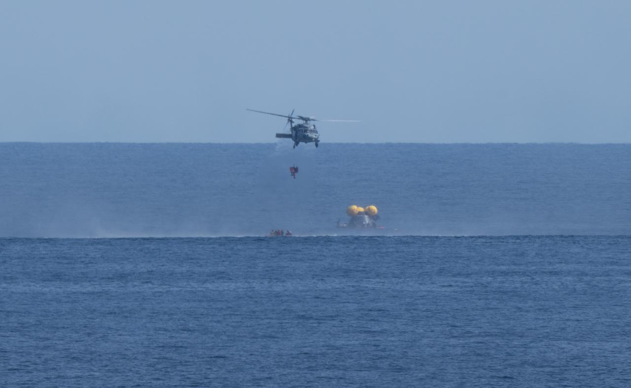 A Navy MH-60 Seahawk from Helicopter Sea Combat Squadron (HSC) 23 is seen as it lifts NASA astronaut Dinez Burnham as teams practice Artemis recovery operations during Underway Recovery Test-12 onboard USS Somerset off the coast of California, Thursday, March 27, 2025. During the test, NASA and Department of Defense teams are practicing to ensure recovery procedures are validated as NASA plans to send the Artemis II astronauts around the Moon and splashdown in the Pacific Ocean.  Photo Credit: (NASA/Joel Kowsky)  3rd lift