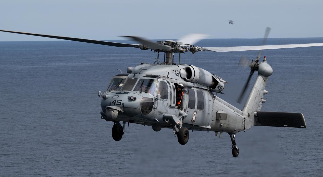 A Navy MH-60 Seahawk from Helicopter Sea Combat Squadron (HSC) 23 approaches USS Somerset after recovering crew from the Crew Module Test Article (CMTA), a full scale replica of the Orion spacecraft, during Underway Recovery Test-12, Thursday, March 27, 2025. During the test, NASA and Department of Defense teams are practicing to ensure recovery procedures are validated as NASA plans to send the Artemis II astronauts around the Moon and splashdown in the Pacific Ocean.  Photo Credit: (NASA/Joel Kowsky)