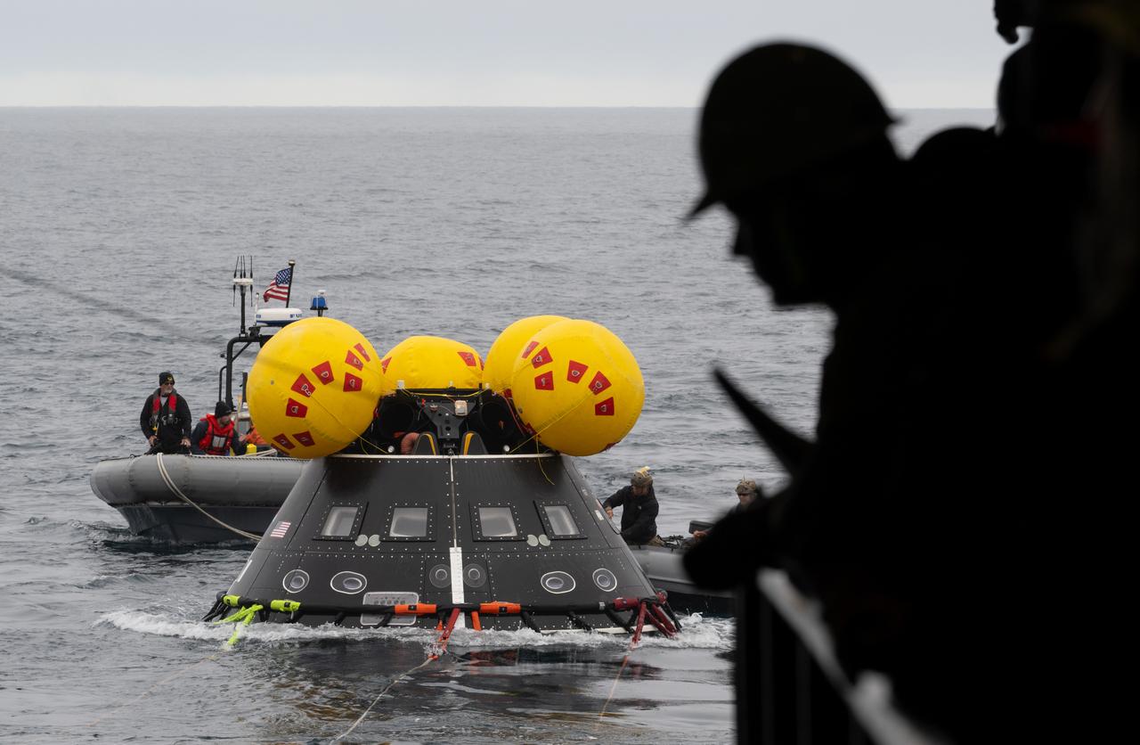 Teams work to recover the Crew Module Test Article (CMTA), a full scale replica of the Orion spacecraft, as they practice Artemis recovery operations during Underway Recovery Test-12 onboard USS Somerset off the coast of California, Thursday, March 27, 2025. During the test, NASA and Department of Defense teams are practicing to ensure recovery procedures are validated as NASA plans to send the Artemis II astronauts around the Moon and splashdown in the Pacific Ocean.  Photo Credit: (NASA/Joel Kowsky)