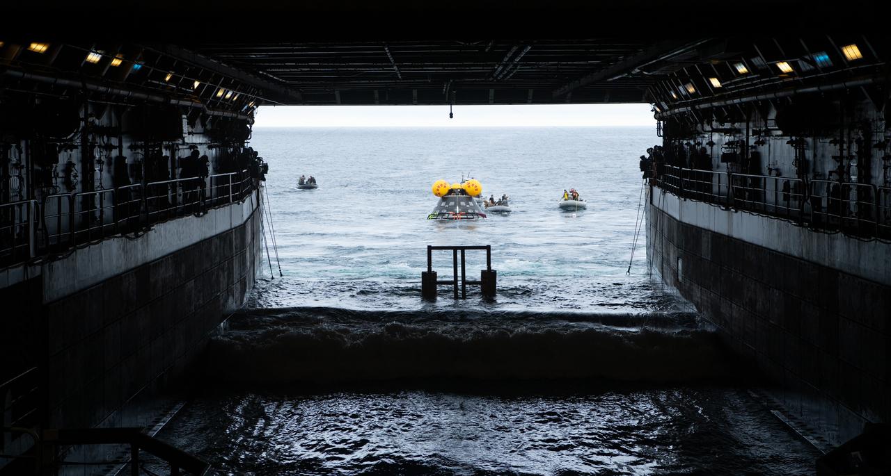 Teams work to recover the Crew Module Test Article (CMTA), a full scale replica of the Orion spacecraft, as they practice Artemis recovery operations during Underway Recovery Test-12 onboard USS Somerset off the coast of California, Thursday, March 27, 2025. During the test, NASA and Department of Defense teams are practicing to ensure recovery procedures are validated as NASA plans to send the Artemis II astronauts around the Moon and splashdown in the Pacific Ocean. Photo Credit: (NASA/Bill Ingalls and Joel Kowsky)