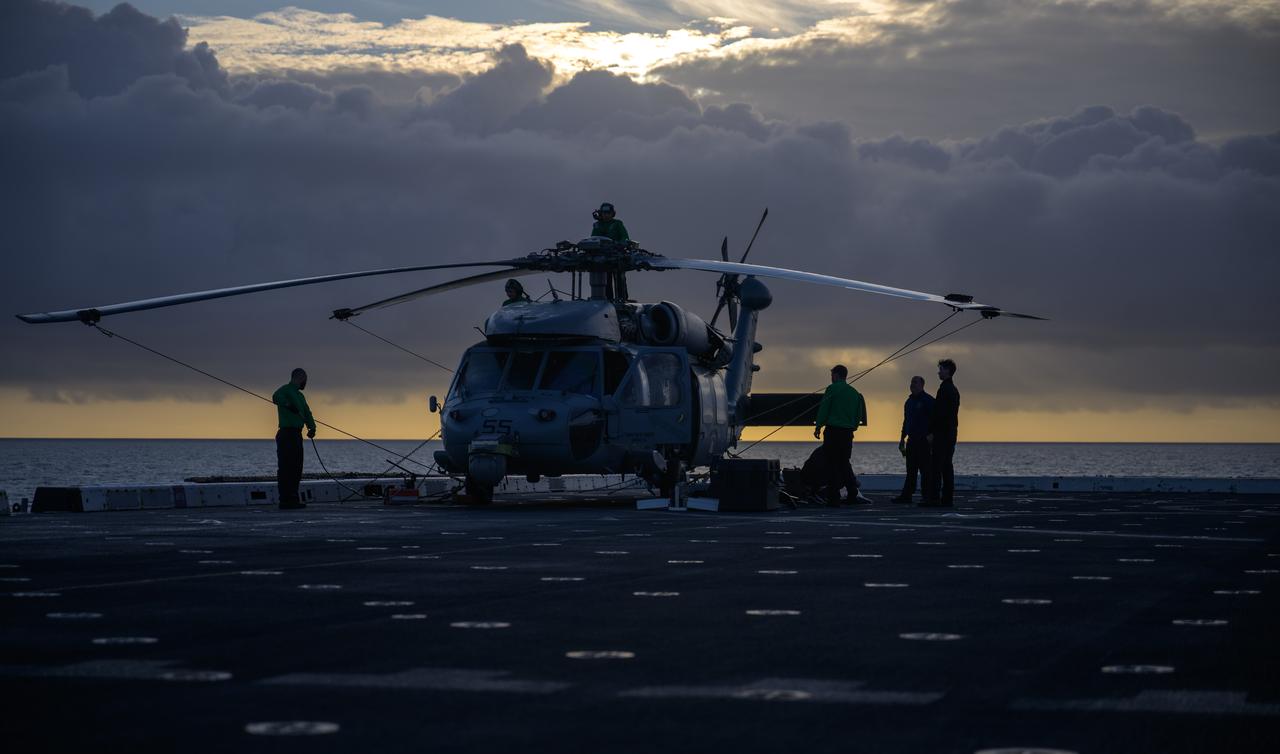 Navy MH-60 Seahawk helicopter team members are seen onboard USS Somerset off the coast of California, as NASA and Department of Defense teams participate in Underway Recovery Test-12, Friday, March 28, 2025. During the test, teams are practicing to ensure recovery procedures are validated as NASA plans to send the Artemis II astronauts around the Moon and splashdown in the Pacific Ocean.  Photo Credit: (NASA/Bill Ingalls)