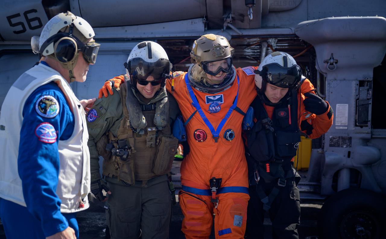 NASA astronaut Deniz Burnham, is helped from a Navy helicopter after returning from the Crew Module Test Article (CMTA), a full scale mockup of the Orion spacecraft, during Underway Recovery Test-12 off the coast of California, Friday, March 28, 2025. During the test, NASA and Department of Defense teams are practicing to ensure recovery procedures are validated as NASA plans to send Artemis II astronauts around the Moon and splashdown in the Pacific Ocean.  Photo Credit: (NASA/Bill Ingalls)