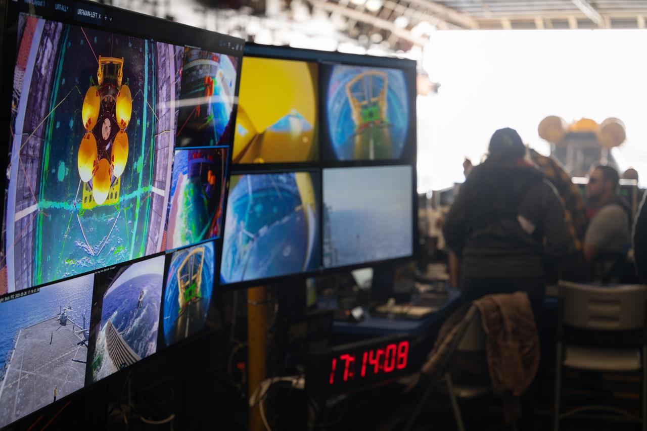 A monitor shows various views from video cameras as teams prepare to release the Crew Module Test Article (CMTA) in the Pacific Ocean during Underway Recovery Test-12 onboard USS Somerset off the coast of California, Friday, March 28, 2025. During the test, NASA and Department of Defense teams are practicing to ensure recovery procedures are validated as NASA plans to send the Artemis II astronauts around the Moon and splashdown in the Pacific Ocean. Photo Credit: (NASA/Joel Kowsky)