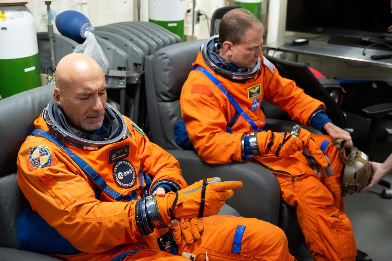 ESA (European Space Agency) astronaut Luca Parmitano, left, and NASA astronaut Stan Love are seen as they prepare to take part in practicing Artemis recovery procedures during Underway Recovery Test-12 onboard USS Somerset off the coast of California, Friday, March 28, 2025. During the test, NASA and Department of Defense teams are practicing to ensure recovery procedures are validated as NASA plans to send the Artemis II astronauts around the Moon and splashdown in the Pacific Ocean.  Photo Credit: (NASA/Joel Kowsky)
