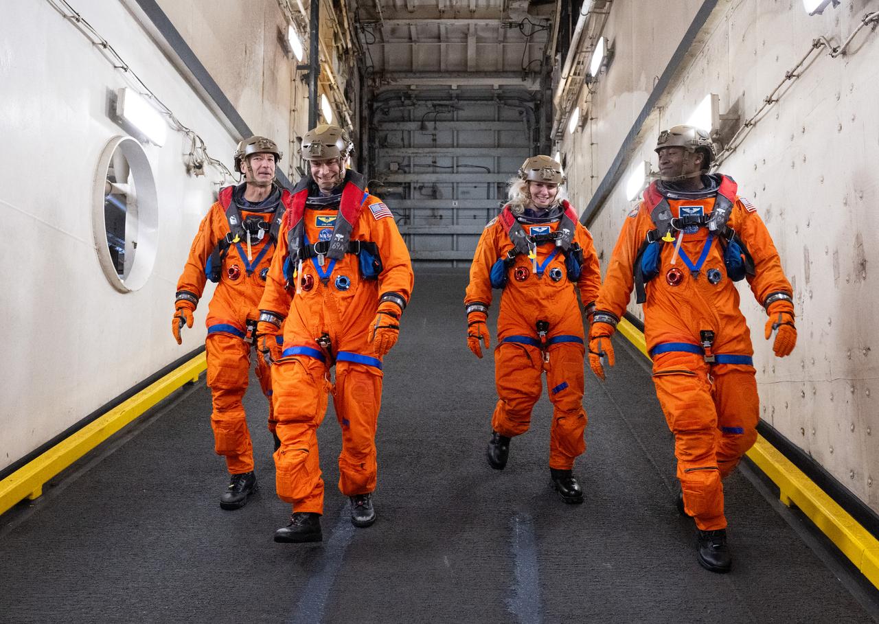 ESA (European Space Agency) astronaut Luca Parmitano, left, and NASA astronauts Stan Love, Deniz Burnham, and Andre Douglas are seen as they prepare to take part in practicing Artemis recovery operations during Underway Recovery Test-12 onboard USS Somerset off the coast of California, Friday, March 28, 2025. During the test, NASA and Department of Defense teams are practicing to ensure recovery procedures are validated as NASA plans to send the Artemis II astronauts around the Moon and splashdown in the Pacific Ocean.  Photo Credit: (NASA/Joel Kowsky)