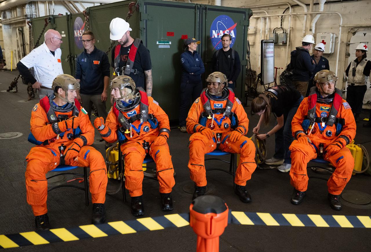 ESA (European Space Agency) astronaut Luca Parmitano, left, and NASA astronauts Deniz Burnham, Andre Douglas, and Stan Love are seen outside the operational clear zone as they prepare to take part in practicing Artemis recovery operations during Underway Recovery Test-12 onboard USS Somerset off the coast of California, Friday, March 28, 2025. During the test, NASA and Department of Defense teams are practicing to ensure recovery procedures are validated as NASA plans to send the Artemis II astronauts around the Moon and splashdown in the Pacific Ocean.  Photo Credit: (NASA/Joel Kowsky)