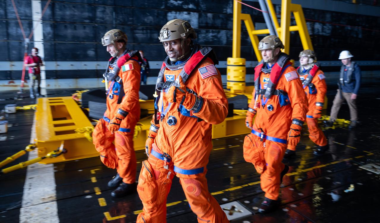 NASA astronaut Andre Douglas gives a thumbs up as he and fellow NASA astronauts Stan Love and Deniz Burnham and ESA (European Space Agency) astronaut Luca Parmitano prepare to be taken to the Crew Module Test Article (CMTA) to take part in practicing Artemis recovery operations during Underway Recovery Test-12 onboard USS Somerset off the coast of California, Friday, March 28, 2025. During the test, NASA and Department of Defense teams are practicing to ensure recovery procedures are validated as NASA plans to send the Artemis II astronauts around the Moon and splashdown in the Pacific Ocean.  Photo Credit: (NASA/Joel Kowsky)