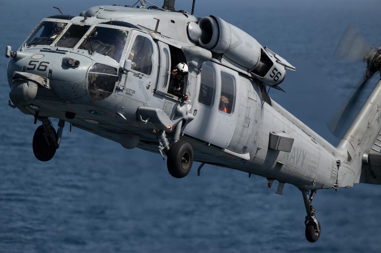 ESA (European Space Agency) astronaut Luca Parmitano is seen in the window as a Navy MH-60 Seahawk from Helicopter Sea Combat Squadron (HSC) 23 returns to USS Somerset as teams practice Artemis recovery operations during Underway Recovery Test-12 off the coast of California, Friday, March 28, 2025. During the test, NASA and Department of Defense teams are practicing to ensure recovery procedures are validated as NASA plans to send the Artemis II astronauts around the Moon and splashdown in the Pacific Ocean.  Photo Credit: (NASA/Joel Kowsky)