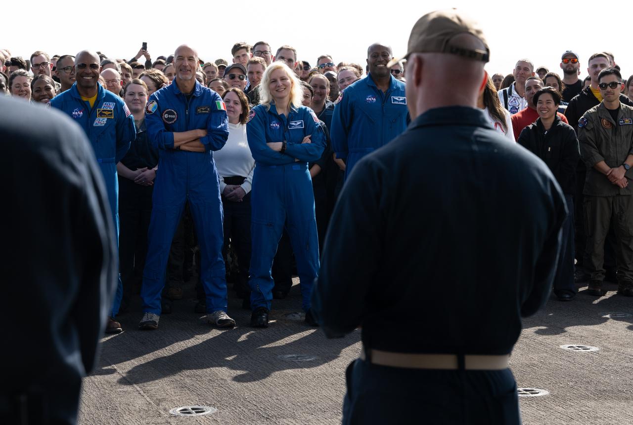 NASA astronauts Victor Glover, ESA (European Space Agency) astronaut Luca Parmitano, and NASA astronauts Dinez Burnham and Andre Douglas look on alongside NASA and Department of Defense teams as Capt. Andrew Koy, commanding officer of USS Somerset addresses them during Underway Recovery Test-12 onboard USS Somerset off the coast of California, Saturday, March 29, 2025. During the test, NASA and Department of Defense teams are practicing to ensure recovery procedures are validated as NASA plans to send the Artemis II astronauts around the Moon and splashdown in the Pacific Ocean. Photo Credit: (NASA/Joel Kowsky)