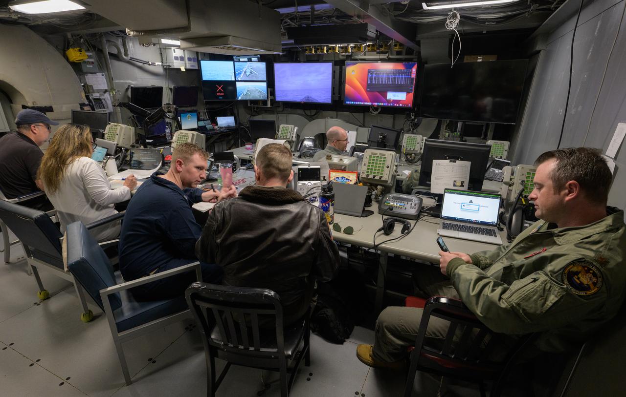 Members of the NASA and Department of Defense recovery team work inside the Landing Force Operations Center onboard USS Somerset as they practice Artemis recovery operations during Underway Recovery Test-12 off the coast of California, Saturday, March 29, 2025. During the test, NASA and Department of Defense teams are practicing to ensure recovery procedures are validated as NASA plans to send Artemis II around the Moon and splashdown in the Pacific Ocean. Photo Credit: (NASA/Bill Ingalls)
