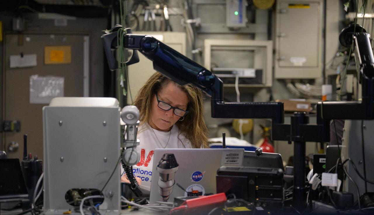 Lisa Seiler, Artemis Landing and Recovery deputy director, works inside the Landing Force Operations Center onboard USS Somerset as they practice Artemis recovery operations during Underway Recovery Test-12 off the coast of California, Saturday, March 29, 2025. During the test, NASA and Department of Defense teams are practicing to ensure recovery procedures are validated as NASA plans to send Artemis II around the Moon and splashdown in the Pacific Ocean.  Photo Credit: (NASA/Bill Ingalls)