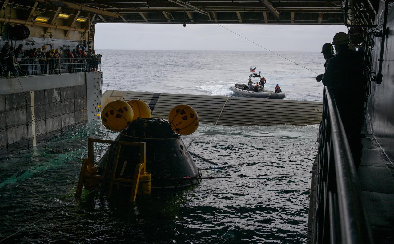 Teams recover the Crew Module Test Article (CMTA), a full scale mockup of the Orion spacecraft, as they practice Artemis recovery operations during Underway Recovery Test-12 onboard USS Somerset off the coast of California, Saturday, March 29, 2025. During the test, NASA and Department of Defense teams are practicing to ensure recovery procedures are validated as NASA plans to send Artemis II around the Moon and splashdown in the Pacific Ocean. Photo Credit: (NASA/Bill Ingalls)