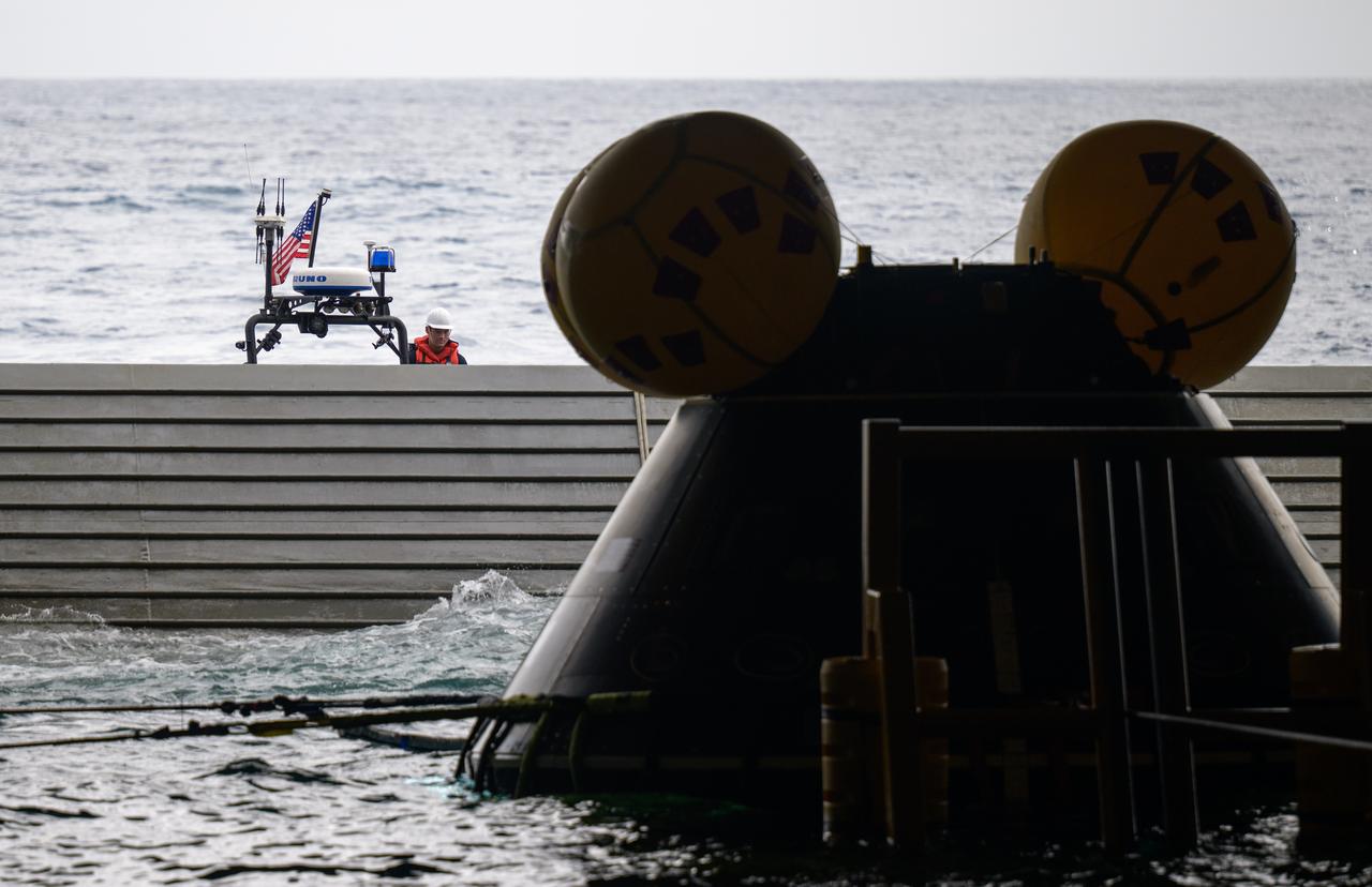 The Crew Module Test Article (CMTA), a full scale mockup of the Orion spacecraft, is seen inside the well deck of USS Somerset as teams practice Artemis recovery operations during Underway Recovery Test-12 off the coast of California, Saturday, March 29, 2025. During the test, NASA and Department of Defense teams are practicing to ensure recovery procedures are validated as NASA plans to send Artemis II around the Moon and splashdown in the Pacific Ocean.  Photo Credit: (NASA/Bill Ingalls)