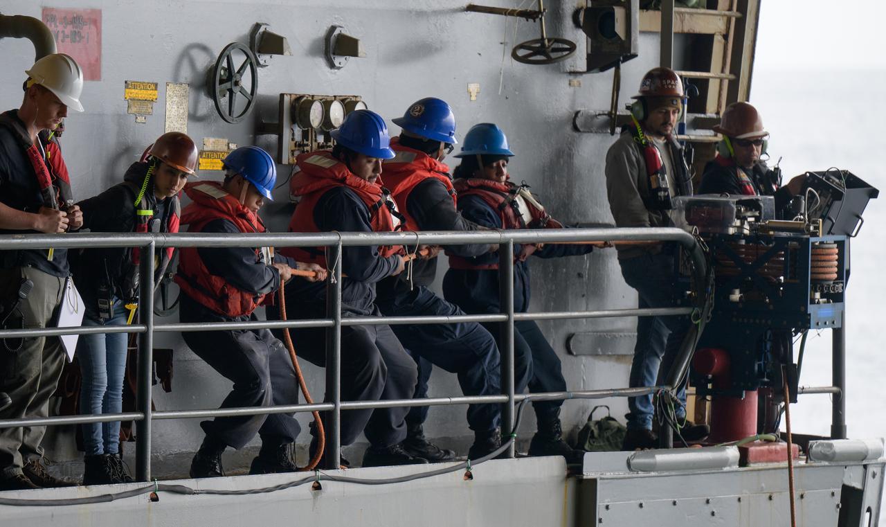 Sailors from USS Somerset assist in the recovery of the Crew Module Test Article (CMTA), a full scale mockup of the Orion spacecraft, as teams practice Artemis recovery operations during Underway Recovery Test-12 onboard USS Somerset off the coast of California, Saturday, March 29, 2025. During the test, NASA and Department of Defense teams are practicing to ensure recovery procedures are validated as NASA plans to send Artemis II around the Moon and splashdown in the Pacific Ocean.  Photo Credit: (NASA/Bill Ingalls)