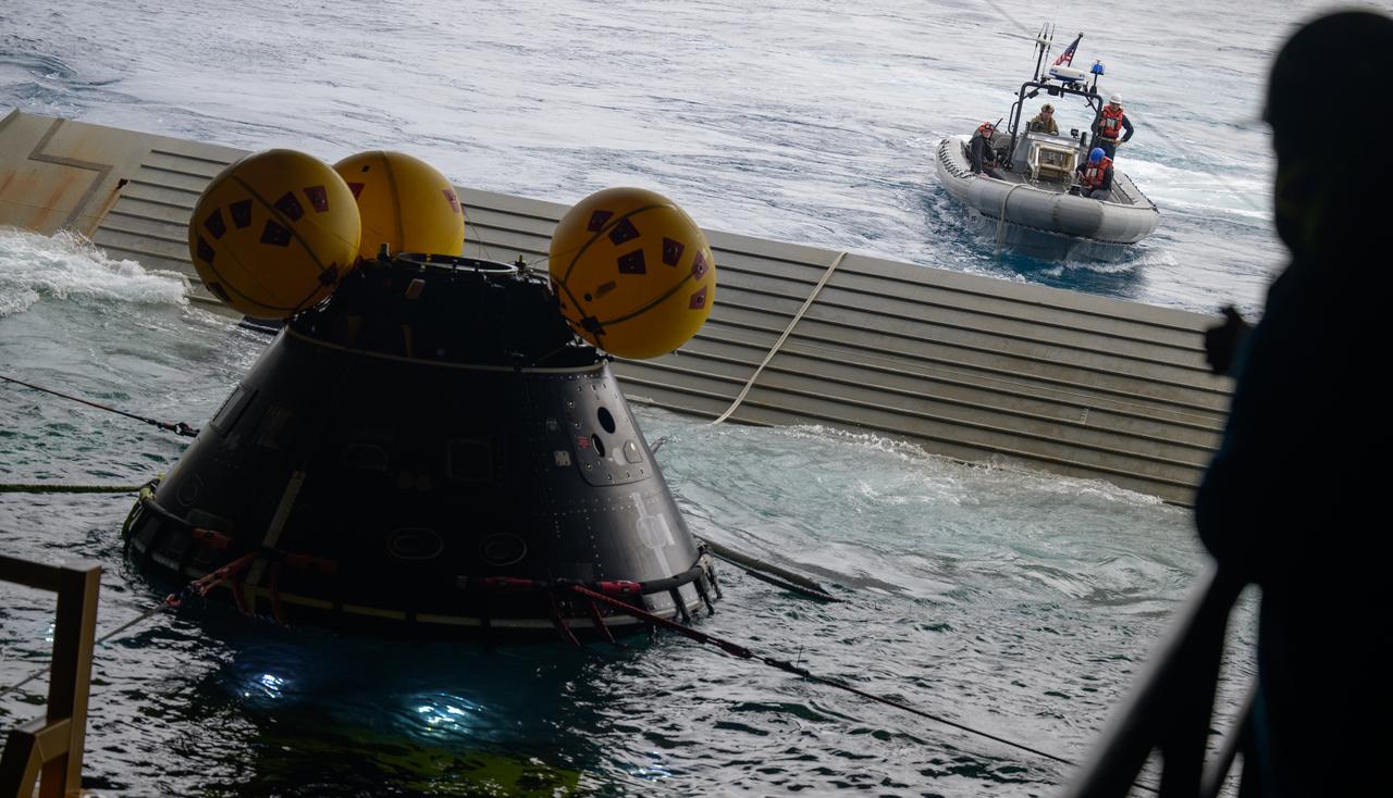 Teams work to recover the Crew Module Test Article (CMTA), a full scale mockup of the Orion spacecraft, as part of practicing Artemis recovery operations during Underway Recovery Test-12 onboard USS Somerset off the coast of California, Saturday, March 29, 2025. During the test, NASA and Department of Defense teams are practicing to ensure recovery procedures are validated as NASA plans to send Artemis II around the Moon and splashdown in the Pacific Ocean.  Photo Credit: (NASA/Bill Ingalls)