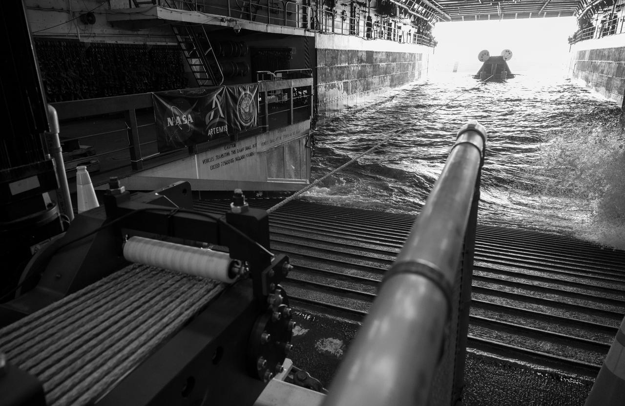 The Crew Module Test Article (CMTA), a full scale mockup of the Orion spacecraft, is seen in the well deck of USS Somerset as teams practice Artemis recovery operations during Underway Recovery Test-12 off the coast of California, Saturday, March 29, 2025. During the test, NASA and Department of Defense teams are practicing to ensure recovery procedures are validated as NASA plans to send Artemis II around the Moon and splashdown in the Pacific Ocean.  Photo Credit: (NASA/Bill Ingalls)