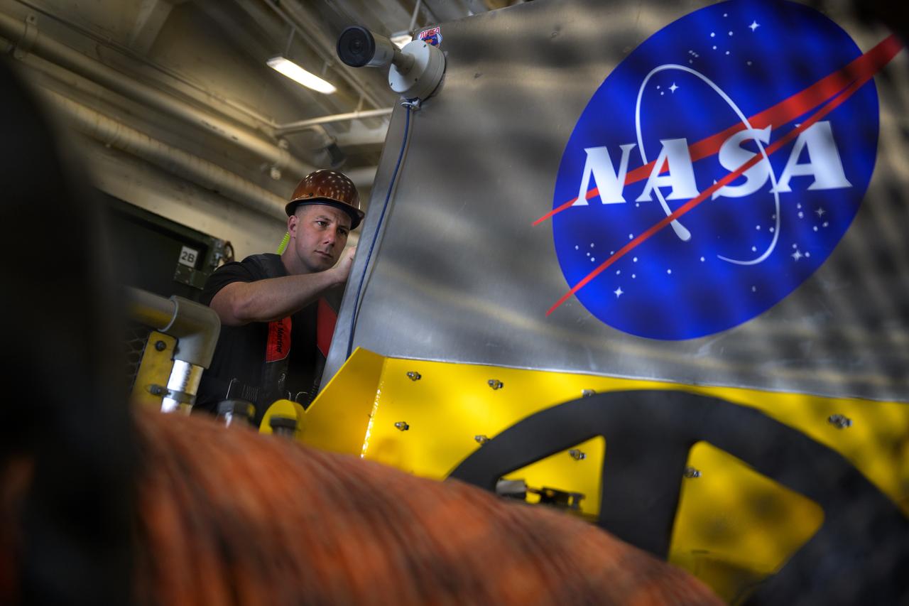 Members of NASA’s Landing and Recovery team are seen as they recover the Crew Module Test Article (CMTA), a full scale mockup of the Orion spacecraft, as teams  practice Artemis recovery operations during Underway Recovery Test-12 onboard USS Somerset off the coast of California, Saturday, March 29, 2025. During the test, NASA and Department of Defense teams are practicing to ensure recovery procedures are validated as NASA plans to send Artemis II around the Moon and splashdown in the Pacific Ocean.  Photo Credit: (NASA/Bill Ingalls)