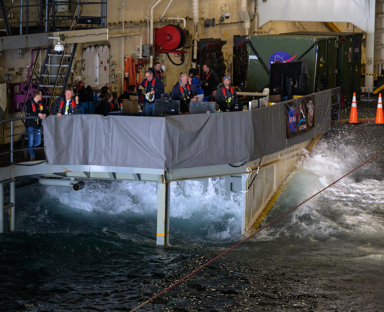 Members of NASA’s Landing and Recovery team are seen as they recover the Crew Module Test Article (CMTA), a full scale mockup of the Orion spacecraft, as teams  practice Artemis recovery operations during Underway Recovery Test-12 onboard USS Somerset off the coast of California, Saturday, March 29, 2025. During the test, NASA and Department of Defense teams are practicing to ensure recovery procedures are validated as NASA plans to send Artemis II around the Moon and splashdown in the Pacific Ocean.  Photo Credit: (NASA/Bill Ingalls)