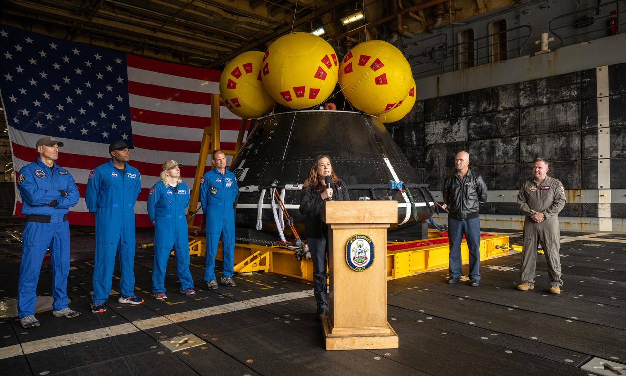Liliana Villarreal, NASA’s Artemis II landing and recovery director, Exploration Ground Systems Program, center, gives remarks as ESA (European Space Agency) astronaut Luca Parmitano, left, NASA astronauts Andre Douglas, Deniz Burnham, Stan Love, Capt. Andrew “Andy” Koy, commanding officer of USS Somerset (LPD 25), U.S. Navy, and Lt. Col. David Mahan, commander, U.S. Air Force’s 1st Air Force, Detachment 3, Patrick Space Force Base, Florida, right, look on during a media event where NASA and the Department of Defense discussed the recovery operations that will bring the Artemis II astronauts and the agency’s Orion spacecraft home at the conclusion of next year’s mission around the Moon, Monday, March 31, 2025, onboard USS Somerset at Naval Base San Diego, in California. The teams spent the week practicing the procedures they will use to recover the astronauts after their more than 600,000 mile journey from Earth to the Moon and back on the first crewed mission under the Artemis campaign. Photo Credit: (NASA/Bill Ingalls)