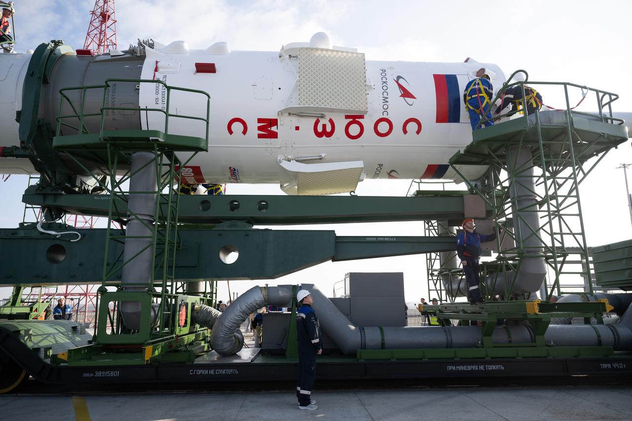 Workers prepare the Soyuz rocket to be raised into the vertical position after it was rolled out by train to the launch pad at Site 31, Saturday, April 5, 2025, at the Baikonur Cosmodrome in Kazakhstan. Expedition 73 crewmembers: NASA astronaut Jonny Kim, and Roscosmos cosmonauts Sergey Ryzhikov and Alexey Zubritskiy, are scheduled to launch aboard their Soyuz MS-27 spacecraft on April 8. Photo Credit: (NASA/Joel Kowsky)