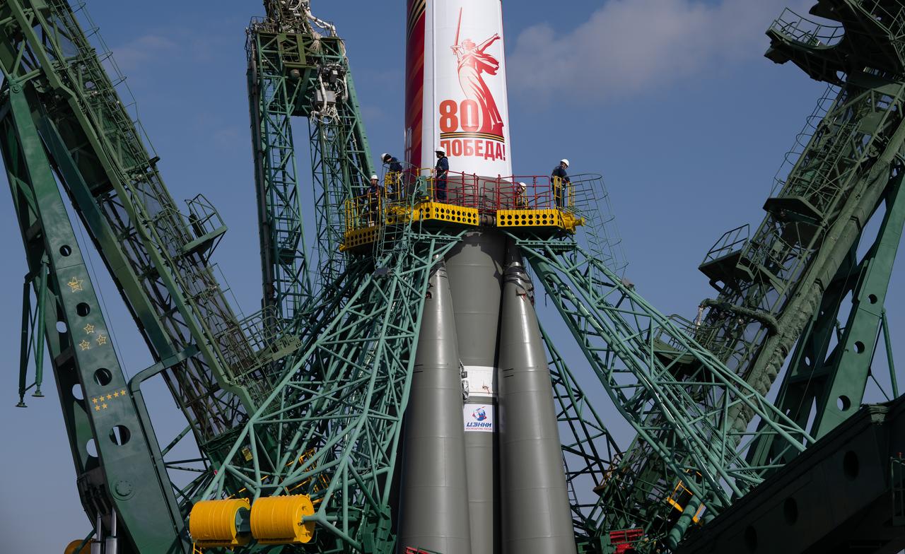Workers are seen in a gantry around the Soyuz rocket as the service structure is closed around it at the launch pad at Site 31, Saturday, April 5, 2025, at the Baikonur Cosmodrome in Kazakhstan. Expedition 73 crewmembers: NASA astronaut Jonny Kim, and Roscosmos cosmonauts Sergey Ryzhikov and Alexey Zubritskiy, are scheduled to launch aboard their Soyuz MS-27 spacecraft on April 8. Photo Credit: (NASA/Joel Kowsky)