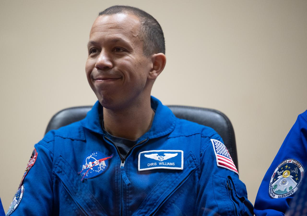Expedition 73 backup crewmember Chris Williams of NASA seen in quarantine, behind glass, during a press conference, Monday, April 7, 2025 a the Cosmonaut Hotel in Baikonur, Kazakhstan. Expedition 73 crew members: NASA astronaut Jonny Kim, and Roscosmos cosmonauts Sergey Ryzhikov and Alexey Zubritskiy, are scheduled to launch aboard their Soyuz MS-27 spacecraft on April 8. Photo Credit: (NASA/Joel Kowsky)