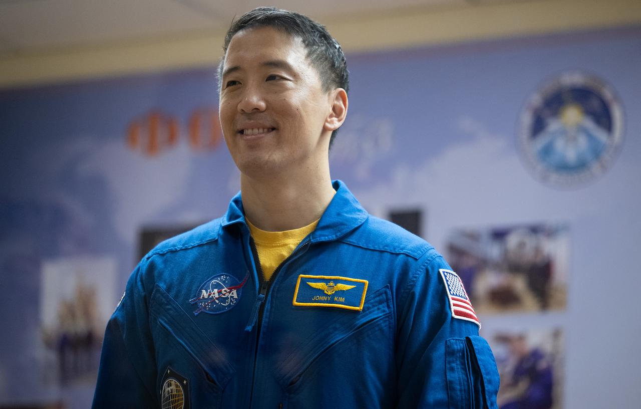 NASA astronaut Jonny Kim is seen in quarantine, behind glass, during a press conference, Monday, April 7, 2025 a the Cosmonaut Hotel in Baikonur, Kazakhstan. Expedition 73 crew members: NASA astronaut Jonny Kim, and Roscosmos cosmonauts Sergey Ryzhikov and Alexey Zubritskiy, are scheduled to launch aboard their Soyuz MS-27 spacecraft on April 8. Photo Credit: (NASA/Joel Kowsky)