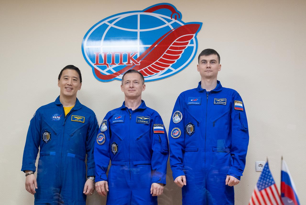 NASA astronaut Jonny Kim, left, and Roscosmos cosmonauts Sergey Ryzhikov and Alexey Zubritskiy seen in quarantine, behind glass, during a press conference, Monday, April 7, 2025 a the Cosmonaut Hotel in Baikonur, Kazakhstan. Kim, Ryzhikov, Zubritskiy are scheduled to launch aboard their Soyuz MS-27 spacecraft on April 8. Photo Credit: (NASA/Joel Kowsky)
