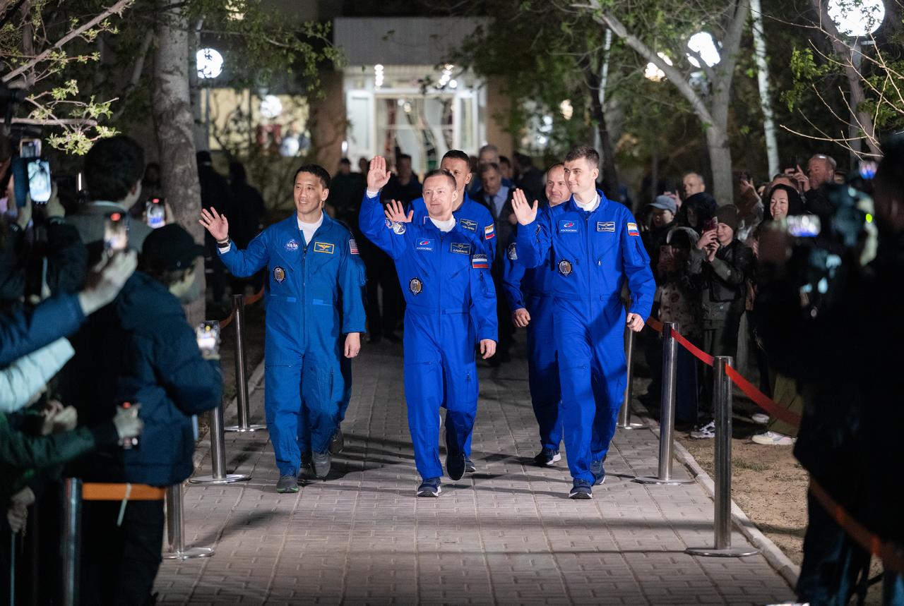 NASA astronaut Jonny Kim, left, and Roscosmos cosmonauts Sergey Ryzhikov and Alexey Zubritskiy, right, wave as they depart the Cosmonaut Hotel to suit-up for their Soyuz launch to the International Space Station, Tuesday, April 8, 2025 (April 7 Eastern Time), in Baikonur, Kazakhstan. The launch will send Kim, Ryzhikov, Zubritskiy on a mission to the International Space Station. Photo Credit: (NASA/Joel Kowsky)