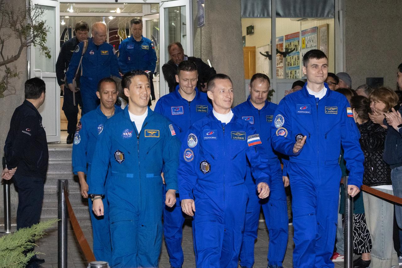 NASA astronaut Jonny Kim, left, and Roscosmos cosmonauts Sergey Ryzhikov, center, and Alexey Zubritskiy, right, are seen as they walk out of the Cosmonaut Hotel as they prepare to head to suit-up for their Soyuz launch to the International Space Station, Tuesday, April 8, 2025, in Baikonur, Kazakhstan. The launch will send Kim, Ryzhikov, Zubritskiy on a mission to the International Space Station. Photo Credit: (NASA/Victor Zelentsov)
