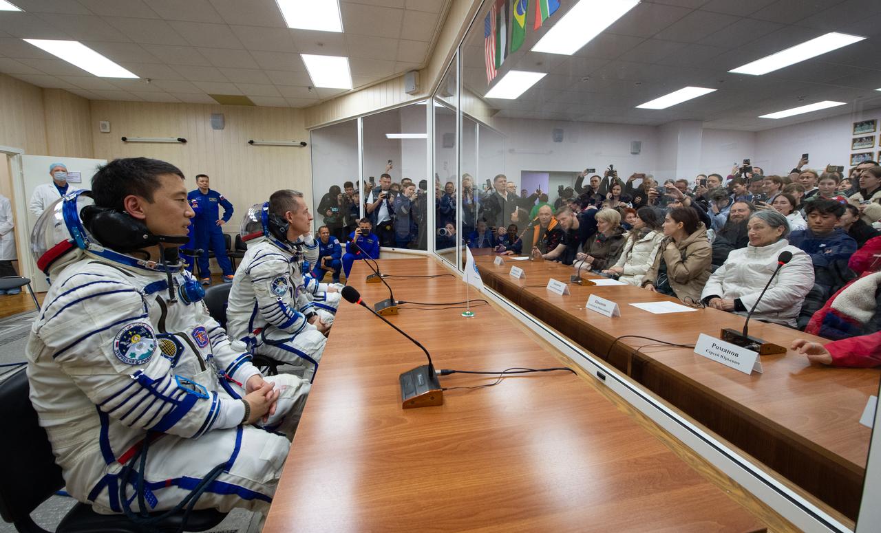 NASA astronaut Jonny Kim, left, and fellow cremates Roscosmos cosmonauts Sergey Ryzhikov and Alexey Zubritskiy, speak to friends and family after having their Russian Sokol Suits pressure checked as they prepare for their Soyuz launch to the International Space Station Tuesday, April 8, 2025 in Baikonur, Kazakhstan. The launch will send Kim, Ryzhikov, Zubritskiy on a mission to the International Space Station. Photo Credit: (NASA/GCTC/Pavel Shvets)