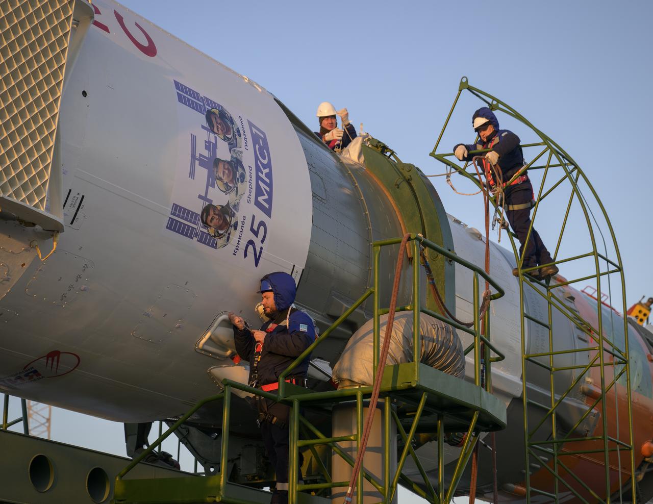 Technicians work on the Soyuz rocket after it was rolled out by train to the launch pad, Monday, Nov. 24, 2025, at Site 31 of the Baikonur Cosmodrome in Kazakhstan. Expedition 74 crewmembers: NASA astronaut Chris Williams, Roscosmos cosmonauts Sergey Kud-Sverchkov and Sergey Mikaev are scheduled to launch aboard their Soyuz MS-28 spacecraft on November 27. Photo Credit: (NASA/Bill Ingalls)