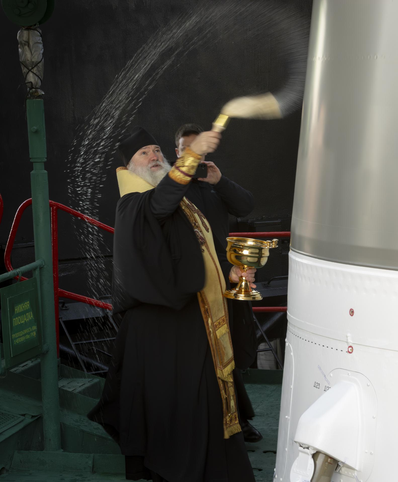 Russian Orthodox Priest blesses the Soyuz rocket, Wednesday, Nov. 26, 2025 at the Baikonur Cosmodrome in Kazakhstan. Expedition 74 crewmembers: NASA astronaut Chris Williams, Roscosmos cosmonauts Sergey Kud-Sverchkov and Sergei Mikaev, are scheduled to launch aboard their Soyuz MS-28 spacecraft on November 27. Photo Credit: (NASA/Victor Zelentsov)