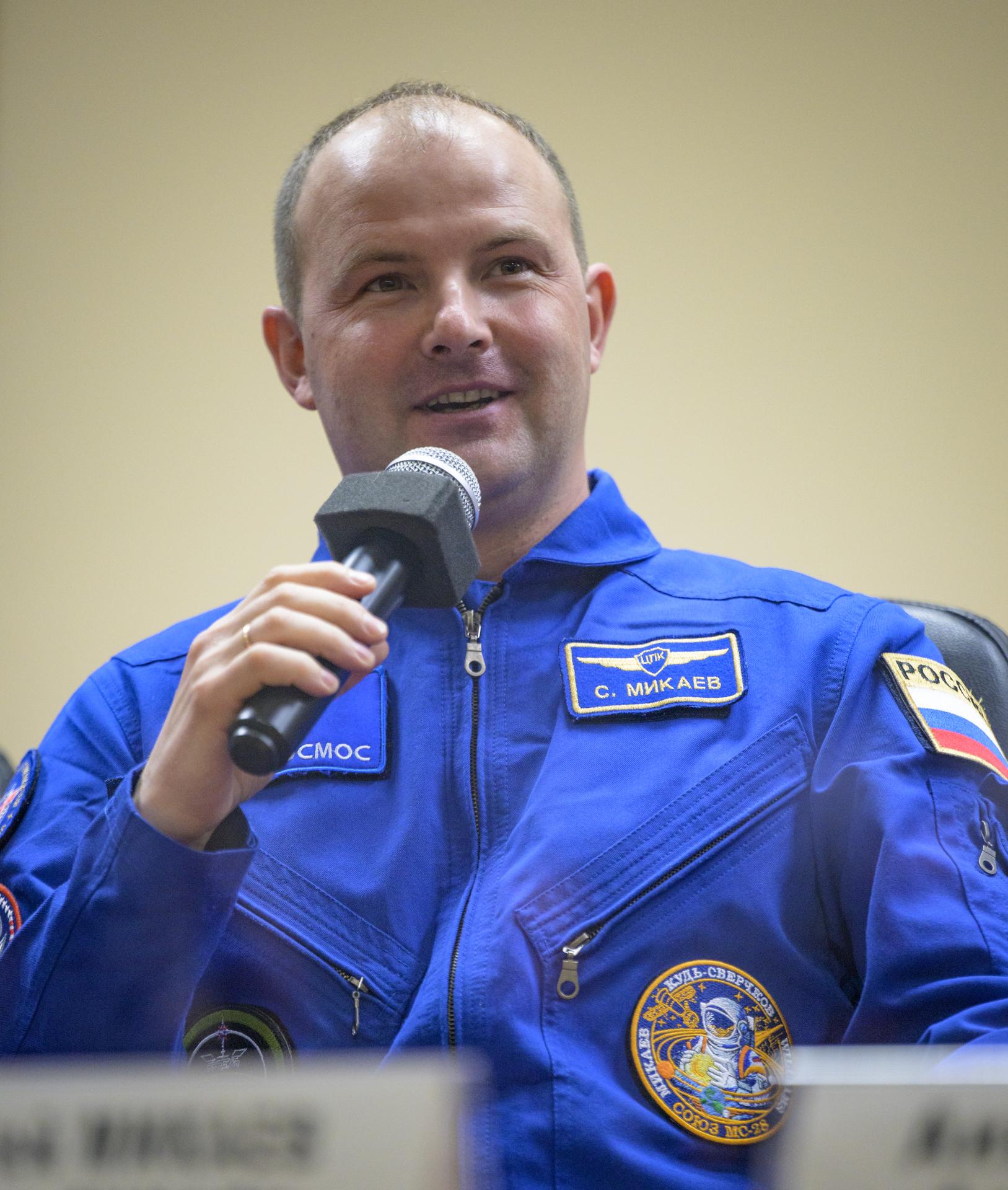 Roscosmos cosmonaut Sergei Mikaev is seen in quarantine, behind glass, during a press conference, Wednesday, Nov. 26, 2025 at the Cosmonaut Hotel in Baikonur, Kazakhstan. Expedition 74 crewmembers: NASA astronaut Chris Williams, Roscosmos cosmonauts Sergey Kud-Sverchkov and Sergei Mikaev, are scheduled to launch aboard their Soyuz MS-28 spacecraft on November 27. Photo Credit: (NASA/Bill Ingalls)