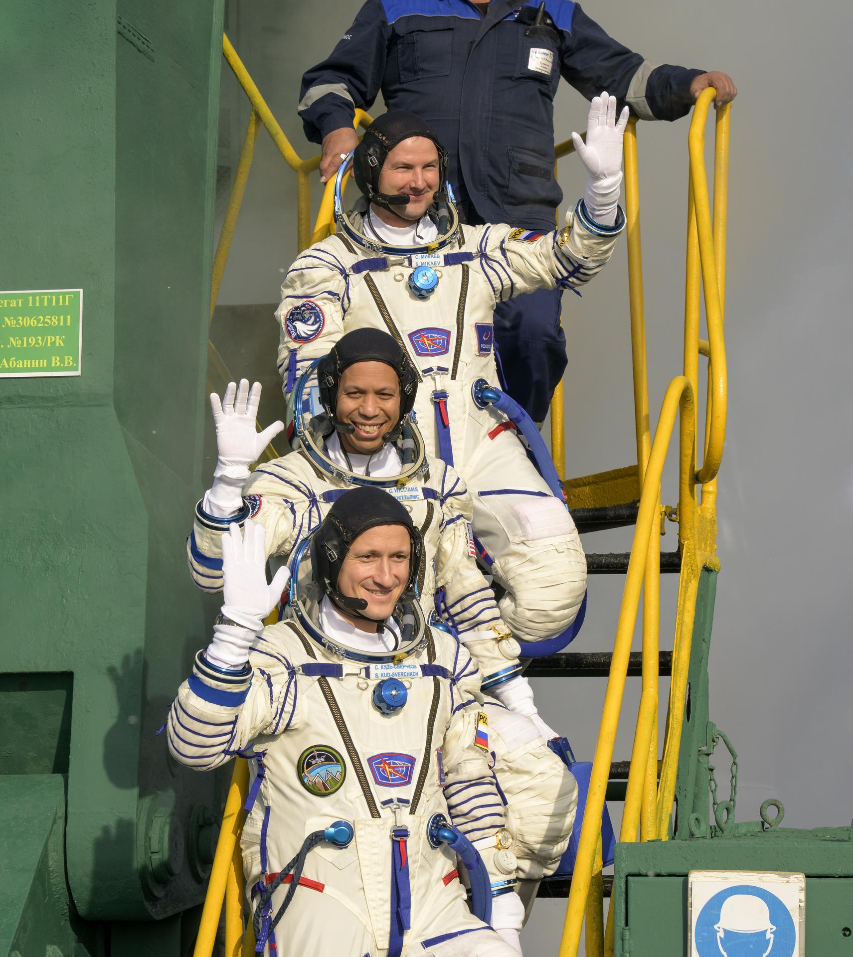 Roscosmos cosmonaut Sergei Mikaev, top,  NASA astronaut Chris Williams, middle, and  Roscosmos cosmonaut Sergey Kud-Sverchkov, wave farewell prior to boarding the Soyuz MS-28 spacecraft for launch, Thursday, Nov. 27, 2025 at the Baikonur Cosmodrome in Kazakhstan. Launch of the Soyuz rocket will send the trio on a mission to the International Space Station. Photo Credit: (NASA/Bill Ingalls)