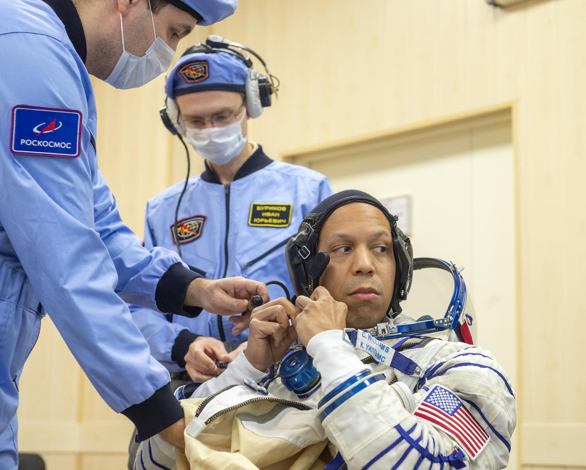 NASA astronaut Chris Williams is helped into his Russian Sokol suit as he and fellow crewmates, Roscosmos cosmonauts Sergei Mikaev, and Sergey Kud-Sverchkov, prepare for their Soyuz launch to the International Space Station Thursday, Nov. 27, 2025 in Baikonur, Kazakhstan. Photo Credit: (NASA/GCTC/Pavel Shvets)