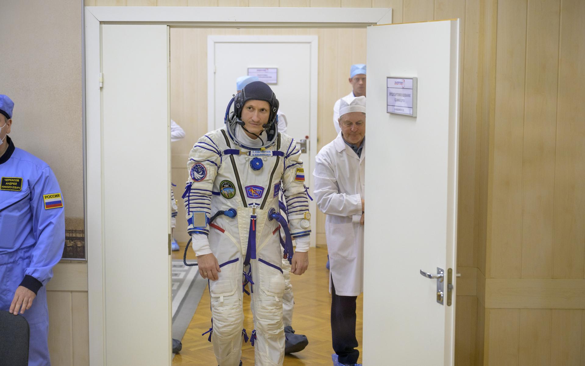 Roscosmos cosmonaut Sergey Kud-Sverchkov walks into a room of building 254 to have his Russian Sokol suit pressure checked as he and fellow crewmates, NASA astronaut Chris Williams, and Roscosmos cosmonaut Sergei Mikaev, prepare for their Soyuz launch to the International Space Station Thursday, Nov. 27, 2025 in Baikonur, Kazakhstan. Photo Credit: (NASA/Bill Ingalls)