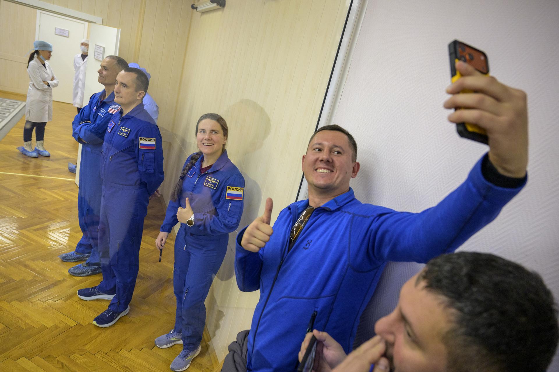 Expedition 74 backup crewmembers: Anil Menon of NASA, background, Roscosmos cosmonauts Petr Dubrov, and Anna Kikina, foreground, are seen behind glass as the prime crew has their Russian Sokol suits pressure checked for their Soyuz launch to the International Space Station Thursday, Nov. 27, 2025 in Baikonur, Kazakhstan. Photo Credit: (NASA/Bill Ingalls)