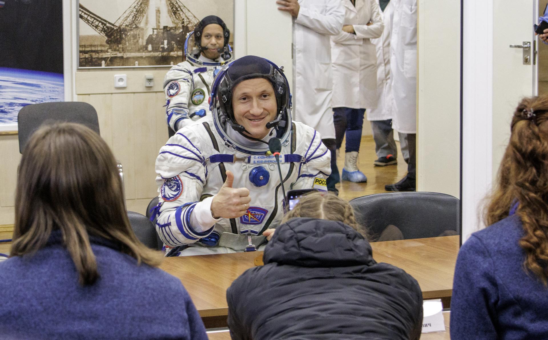 Roscosmos cosmonaut Sergey Kud-Sverchkov talks to his family after having his Russian Sokol suit pressured checked as he and crew mates, NASA astronaut Chris Williams, and Roscosmos cosmonaut Sergei Mikaev, prepare for their Soyuz launch to the International Space Station Thursday, Nov. 27, 2025 in Baikonur, Kazakhstan. Photo Credit: (NASA/Victor Zelentsov)