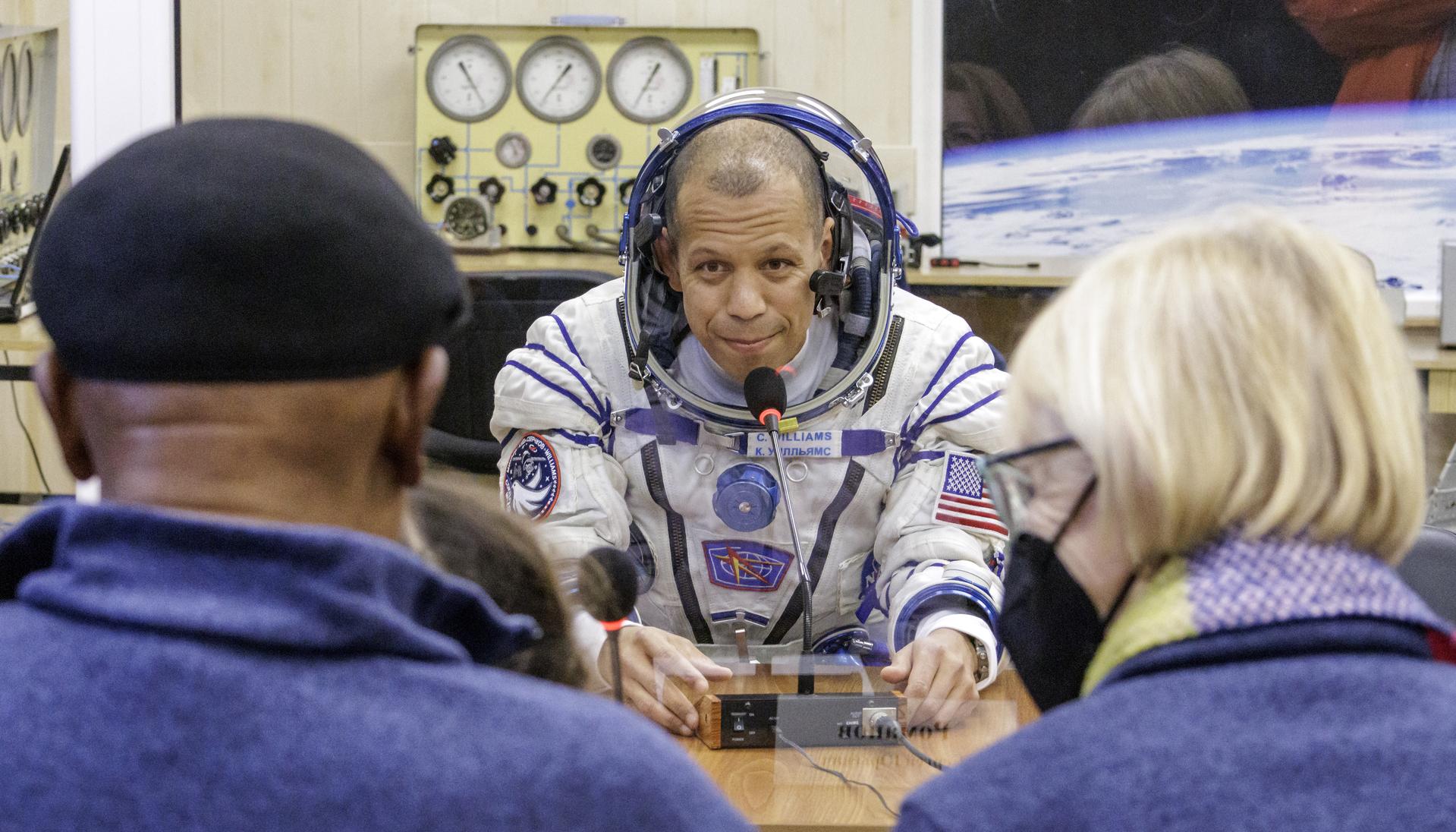 NASA astronaut Chris Williams talks to his family after having his Russian Sokol suit pressured checked as he and crew mates, Roscosmos cosmonauts Sergei Mikaev, and Sergey Kud-Sverchkov, prepare for their Soyuz launch to the International Space Station Thursday, Nov. 27, 2025 in Baikonur, Kazakhstan. Photo Credit: (NASA/Victor Zelentsov)