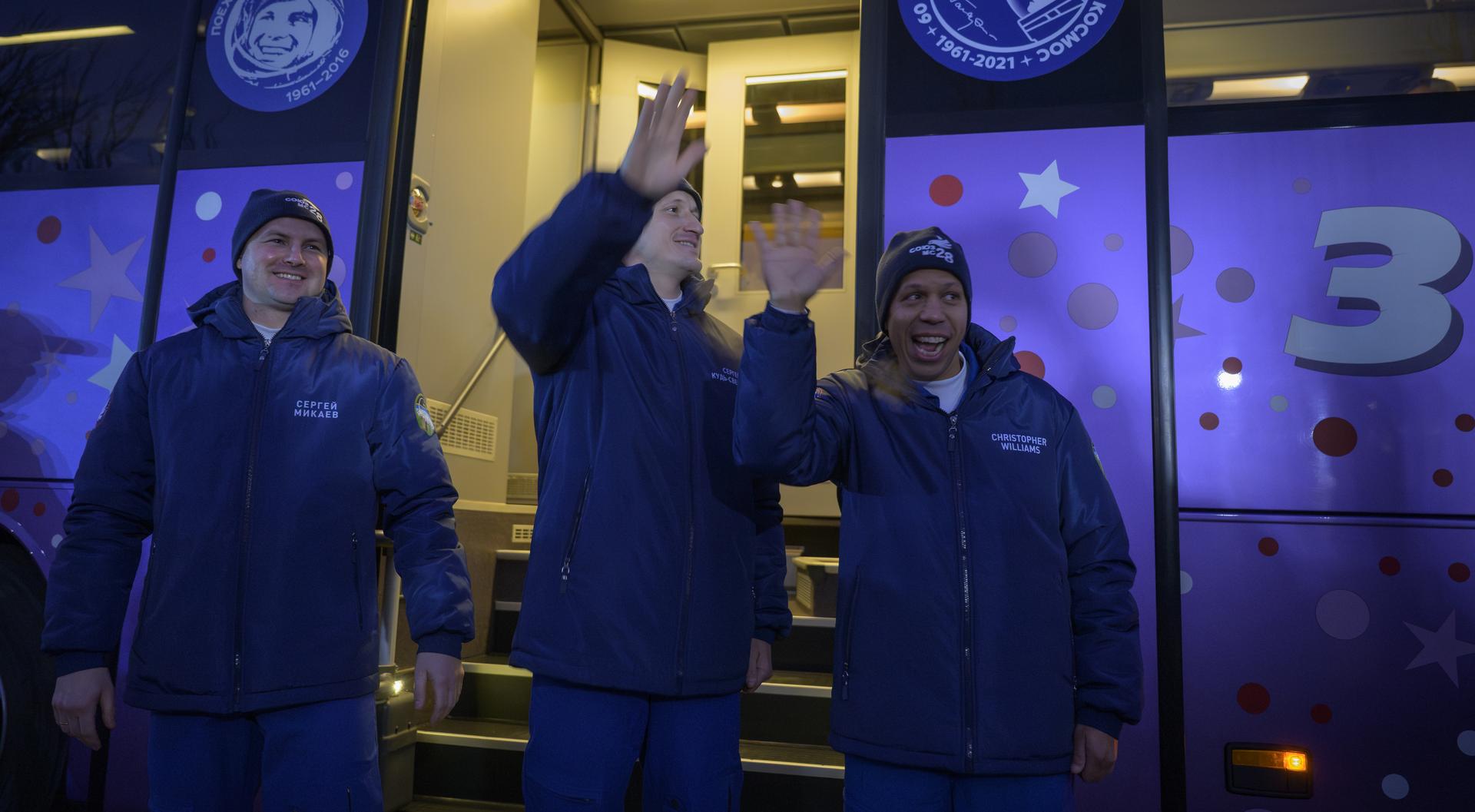 Roscosmos cosmonauts Sergei Mikaev, left, Sergey Kud-Sverchkov, and NASA astronaut Chris Williams, right, wave farewell as they depart the Cosmonaut Hotel to suit-up for their Soyuz launch, Thursday, Nov. 27, 2025, in Baikonur, Kazakhstan. The launch will send Williams, Kud-Sverchkov and Mikaev, on a mission to the International Space Station. Photo Credit: (NASA/Bill Ingalls)