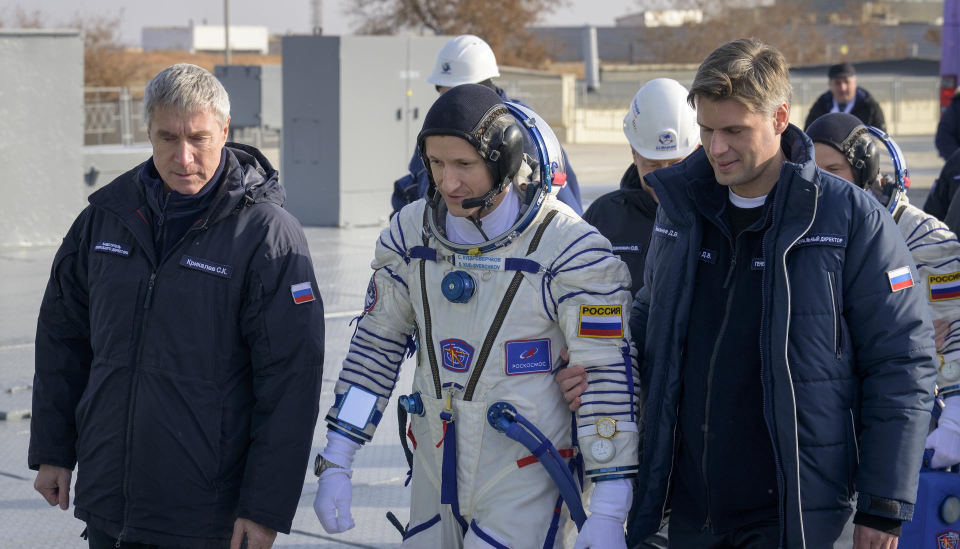 Roscosmos cosmonaut Sergey Kud-Sverchkov, walks to board the Soyuz rocket with, Sergei Krikalev, left, and Roscosmos Director General Yuriy Borisov, Thursday, Nov. 27, 2025 at the Baikonur Cosmodrome in Kazakhstan. Launch of the Soyuz rocket will send Kud-Sverchkov, Roscosmos cosmonaut Sergei Mikaev, and NASA astronaut Chris Williams, on a mission to the International Space Station. Photo Credit: (NASA/Bill Ingalls)