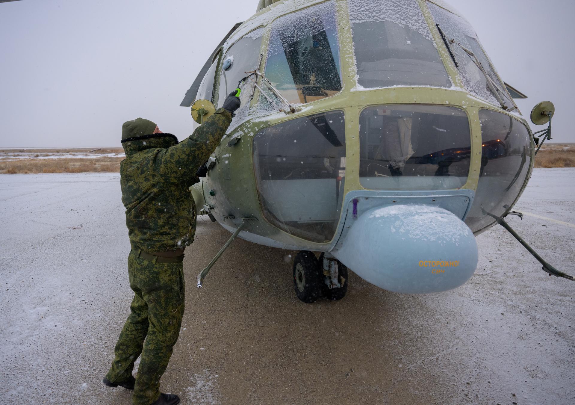 NASA, Roscosmos, and Russian Search and Recovery Forces prepare wait to board helicopters at the Zhezkazgan Airport in Kazakhstan to support the landing of Expedition 73 NASA astronaut Jonny Kim, and Roscosmos cosmonauts Sergey Ryzhikov, and Alexey Zubritsky, Tuesday, Dec. 9, 2025. The trio are returning to Earth after logging 245 days in space as a members of Expeditions 72 and 73 aboard the International Space Station. Photo Credit: (NASA/Bill Ingalls)