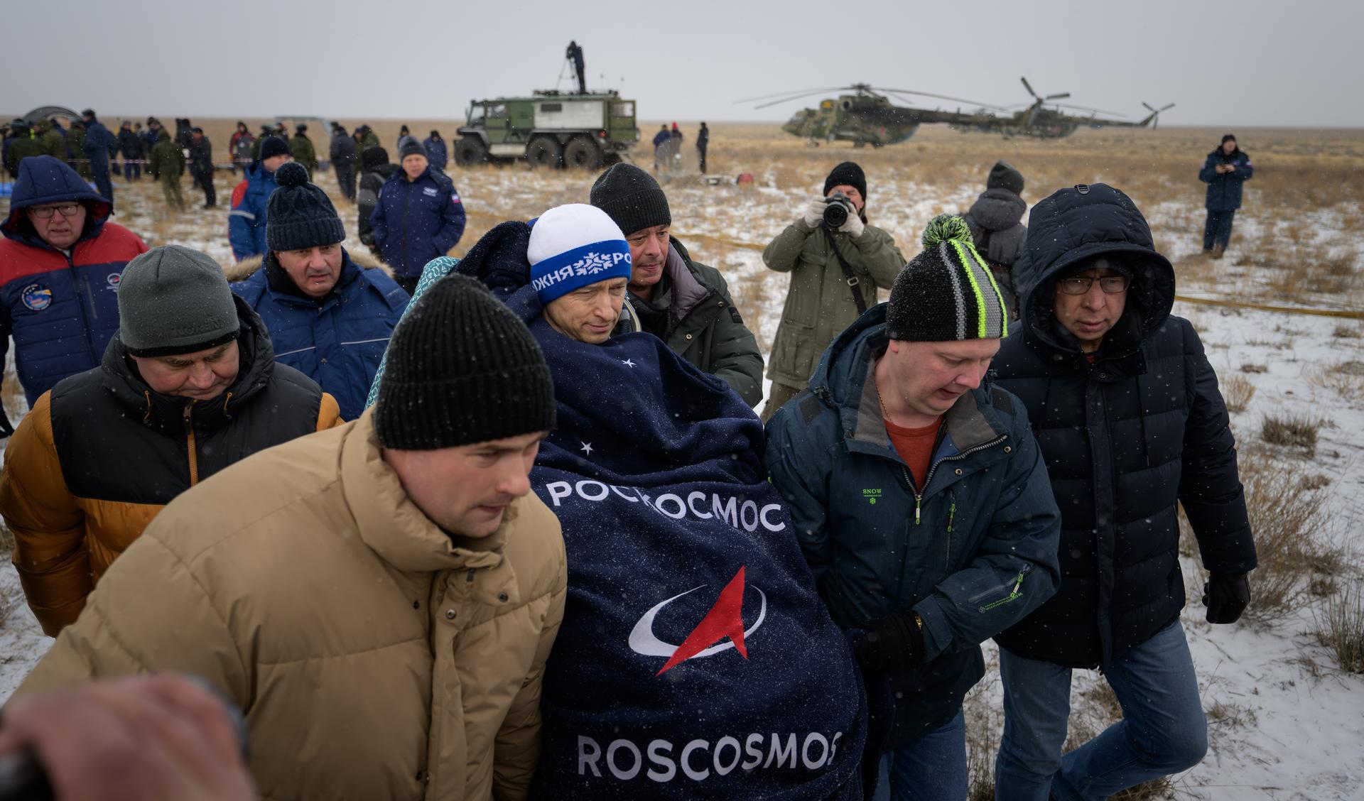 Roscosmos cosmonaut Sergey Ryzhikov is carried to a medical tent shortly after he, NASA astronaut Jonny Kim, and Roscosmos cosmonaut Alexey Zubritsky, landed in their Soyuz MS-27 spacecraft near the town of Zhezkazgan, Kazakhstan on Tuesday, Dec. 9, 2025. The trio returned to Earth after logging 245 days in space as a members of Expeditions 72 and 73 aboard the International Space Station. Photo Credit: (NASA/Bill Ingalls)