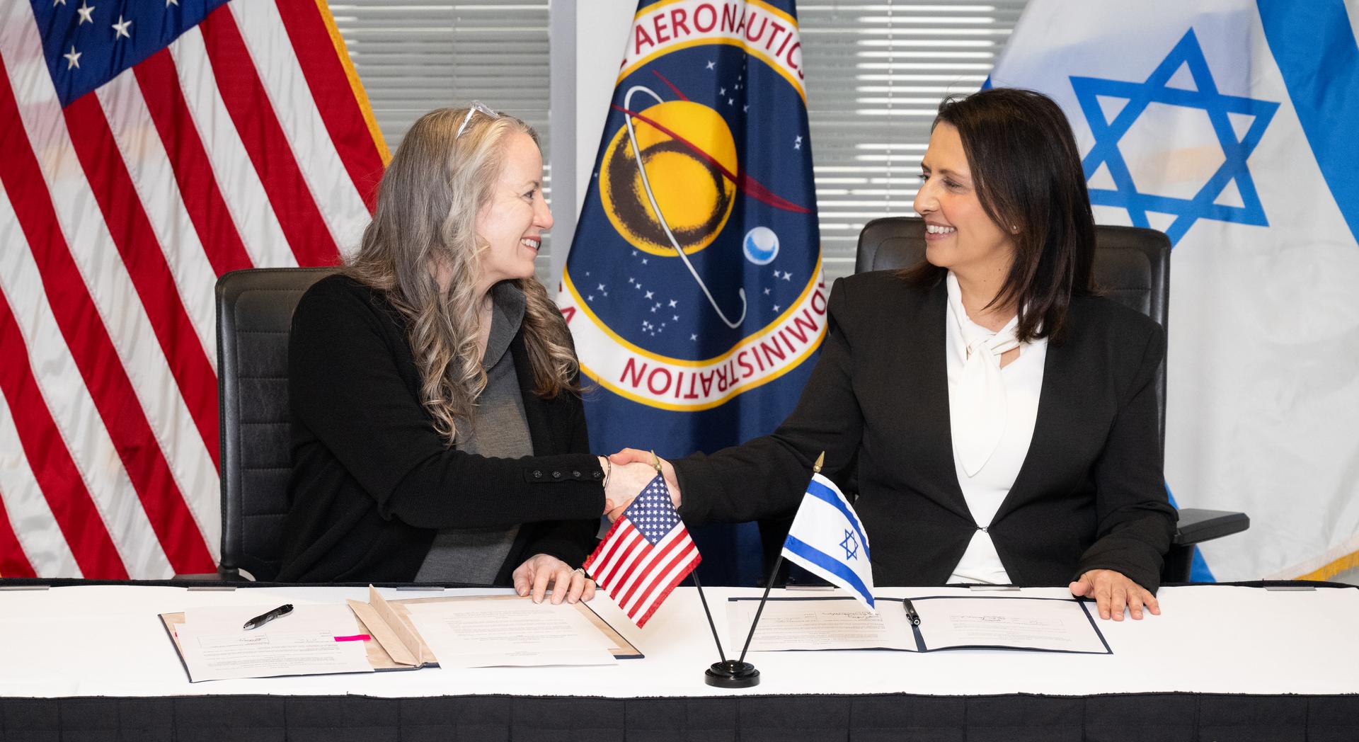 Meredith McKay, acting associate administrator for NASA’s Office of International and Interagency Relations, left, and Israel’s Minister for Innovation, Science, and Technology Gila Gamliel shake hands after signing the US-Israel Space Cooperation Framework Agreement Extension, Wednesday, Dec. 10, 2025, at the Mary W. Jackson NASA Headquarters building in Washington. Photo Credit: (NASA/Joel Kowsky)