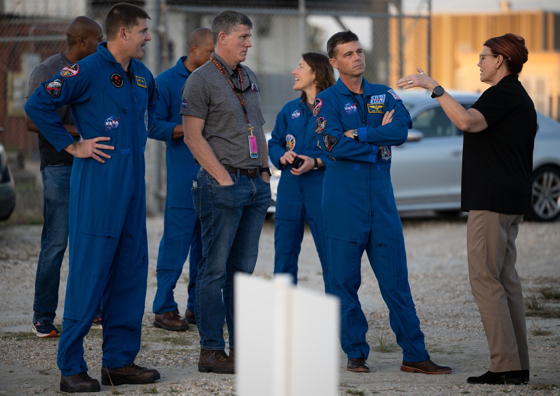 Charlie Blackwell-Thompson, Artemis II Launch Director, right, and Jeremy Graeber, Artemis II Assistant Launch Director, second from left, talk to NASA astronaut Reid Wiseman, Artemis II commander, second from right, and CSA (Canadian Space Agency) astronaut Jeremy Hansen, Artemis II mission specialist, as teams at NASA's Kennedy Space Center in Florida practiced various emergency rescue training scenarios with the Artemis II crew, Friday, Dec. 19, 2025, ahead of the Artemis II mission. In the unlikely event of an emergency during launch countdown at Launch Complex 39B, personnel will be transported in mine-resistant ambush protected vehicles, or MRAPS, from the pad and to one of the triage site locations at Kennedy. Photo Credit: (NASA/Joel Kowsky)   NOTE - Portions of this image have been blurred for security reasons.