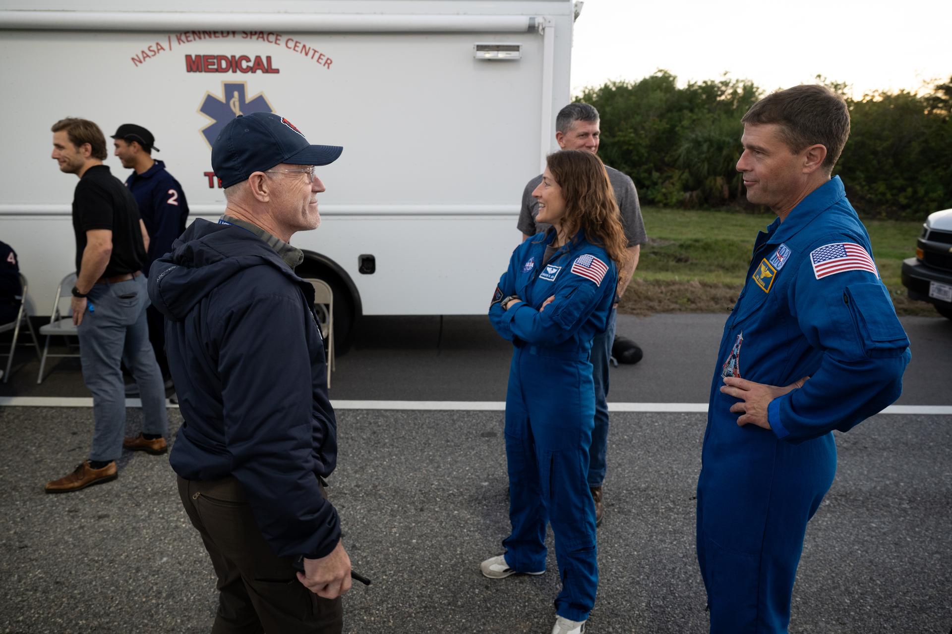NASA Flight Surgeon Richard Scheuring, left, talks with NASA astronauts Reid Wiseman, Artemis II commander, right, and Christina Koch, Artemis II mission specialist, as teams at NASA's Kennedy Space Center in Florida practiced various emergency rescue training scenarios with the Artemis II crew, Friday, Dec. 19, 2025, ahead of the Artemis II mission. In the unlikely event of an emergency during launch countdown at Launch Complex 39B, personnel will be transported in mine-resistant ambush protected vehicles, or MRAPS, from the pad and to one of the triage site locations at Kennedy. Photo Credit: (NASA/Joel Kowsky)